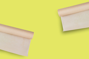 Two rolls of brown baker paper on yellow table on cuisine with copy space for your text. Top view....
