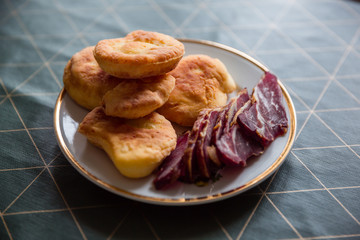 A plate of dried meat and buns.