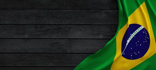Fotobehang Vlag van Brazilië, stof op donker hout. © Negro Elkha