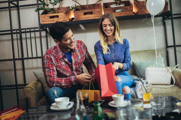 Young couple enjoying in modern cafe after shopping.