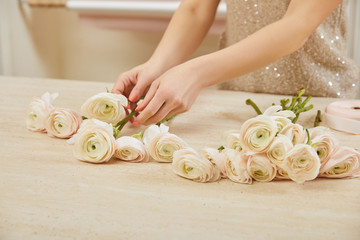 partial view of florist making bouquet of white peonies