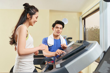 Woman training with instructor on treadmill