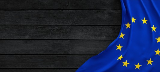 Flag of the European Union, fabric on dark wood.