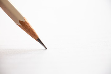 Hand writing letter on white paper background, A white pencil, Close up & Macro shot, Selective focus, Stationery concept