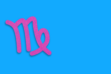 Symbol of astrological sign virgo cut out of purple paper on blue table. Top view. Horoscope concept. Copy space for your text