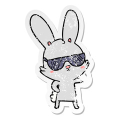 Fototapeta na wymiar distressed sticker of a cute cartoon rabbit wearing sunglasses