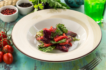 salad with baked beet and bell pepper on blue wooden table