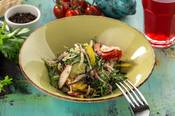 Fresh organic lettuce salad with walnuts radishes and bell pepper on blue wooden table