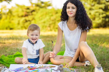 Fototapeta premium Mother and son draw outdoor. Concept of happy family