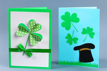 Diy St Patricks Day greeting card made cardboard and paper clovers gray background. Gift idea, decor
