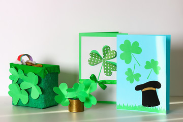 Diy St Patricks Day greeting card made cardboard and paper clovers gray background. Gift idea, decor