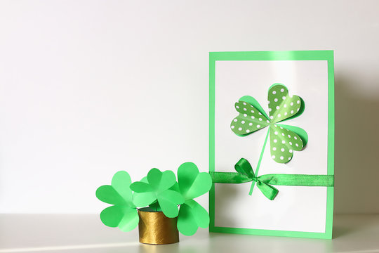 Diy St Patricks Day greeting card made cardboard and paper clovers gray background. Gift idea, decor