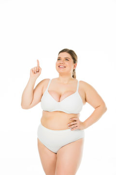smiling overweight girl in underwear showing idea sign isolated on white, body positivity concept