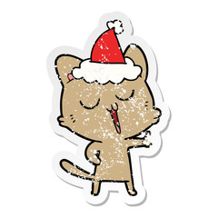 distressed sticker cartoon of a cat singing wearing santa hat