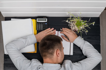 Tired manager falling asleep over the paperwork in the office