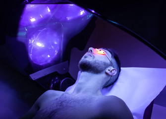 Young Man At Solarium In Beauty Salon.