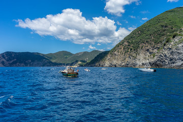 Obraz premium Italy, Cinque Terre, Monterosso, a small boat in a body of water with a mountain in the background