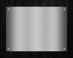 Shiny metal signboard with copy space for text on black board texture background.