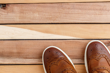 Brown men's shoes on wooden background. Top view