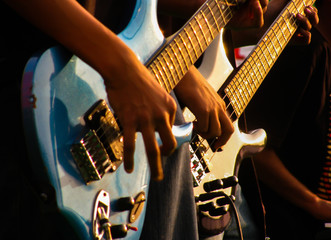This is a low angle photo of two teenage guitarists from a band performing in a live show. Battle...