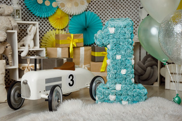 Birthday gold and silver decorations with gifts, toys, garlands and figure for little baby party on...