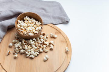 Salt popcorn on the wooden table. Popcorn in a wooden bowl.