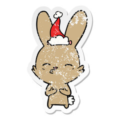 curious bunny distressed sticker cartoon of a wearing santa hat