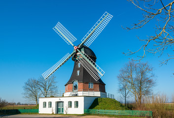 Windmühle in Oldeswort in Schleswig-Holstein vor blauem wolkenlosen Himmel