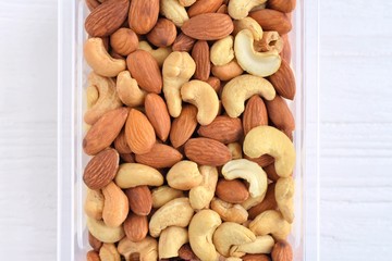 mixed nuts with selective focus on neutral background. Roasted almond and cashew nuts. Delicious natural healthy protein snack. Cashews and almonds nut for vegan daily nutrition 