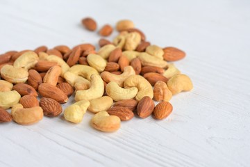 mixed nuts with selective focus on neutral background. Roasted almond and cashew nuts. Delicious natural healthy protein snack. Cashews and almonds nut for vegan daily nutrition 