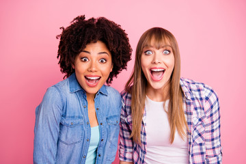 Close up photo two diversity  ladies different race skin open mouth yeah cool unbelievable triumph lucky wear casual jeans denim checkered shirt clothes outfit isolated pink background