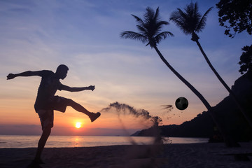 Silhouette Volley Kick football on the beach, Asian man play soccer at sunrise