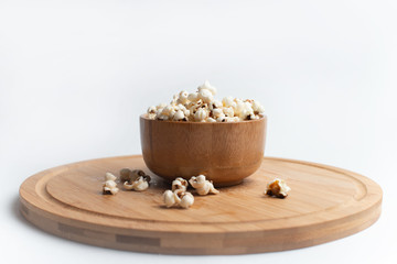 Salt popcorn on the wooden table. Popcorn in a wooden bowl.