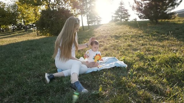 Slow motion of mother and daughter in flare sunset in park