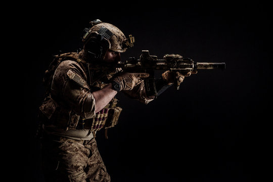 Special forces United States soldier or private military contractor holding rifle. Image on a black background. war, army and people concept