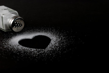 Weltnierentag, Herzbild aus weißem Salz auf schwarzem Papierhintergrund mit Kopierfläche für Werbetreibende. Gesundheits- und Nierenkonzept. © Phongsakorn