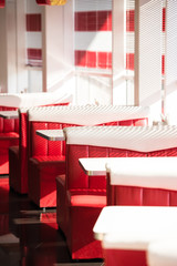 interior of cafe with red sofas and white tables