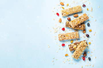 Granola bar with nuts, fruits and berries on blue.