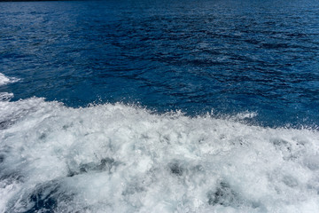 Italy, Cinque Terre, Monterosso, a man riding a wave on top of a body of water