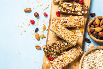 Granola bar with nuts, fruits and berries on blue.