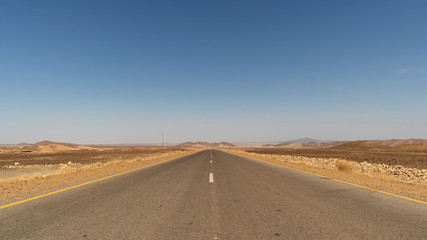 Fototapeta na wymiar The journey to Danakil Depression is long but most of it is today paved. An empty road of Afar region in Ethiopia.