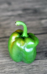 Green paprika on wood background.