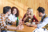 handsome and attractive friends talking and smiling at cafe