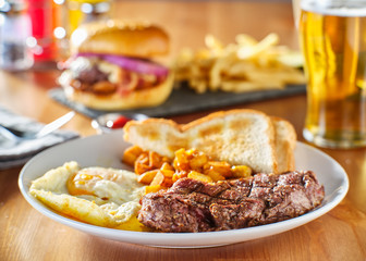 steak and eggs breakfast with toast and homestyle potatoes in restaurant
