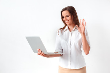 Online communication. Woman standing isolated on white having video call on laptop waving to camera cheerful