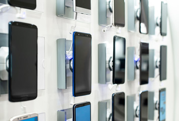 Smartphones on shelf in the store. Concept for communications and technology. - 253095453
