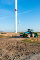 Bauer mit seinem Traktor in Dithmarschen Schleswig-Holstein mitten in einem riesigen Windpark