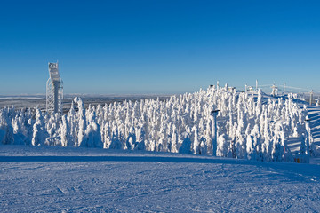 Kuusamo / Finland: Magnificent view to the west from Saarua top with the large ski jumping tower in the Ruka ski area over Lapland on a beautiful day in February