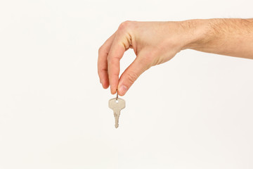 Man's hand holds a key isolated on a white background