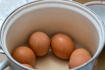 Raw chicken eggs in a pan in the kitchen